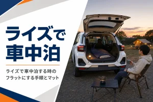 夕暮れのキャンプ場でバックドアを開けた荷室にマットと寝袋を敷いたコンパクトSUV